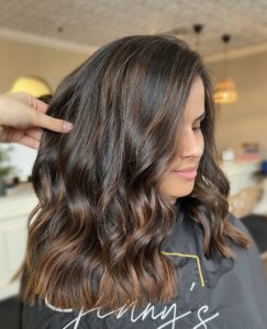 A happy client showing off her new Balayage hair style at Jenny's Salon