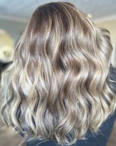 A happy client showing off her new Balayage hair treatment at Jenny's Salon