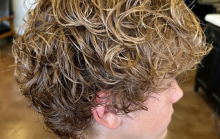 Happy client showing off his new broccoli head haircut after getting a perm at Jenny's Salon