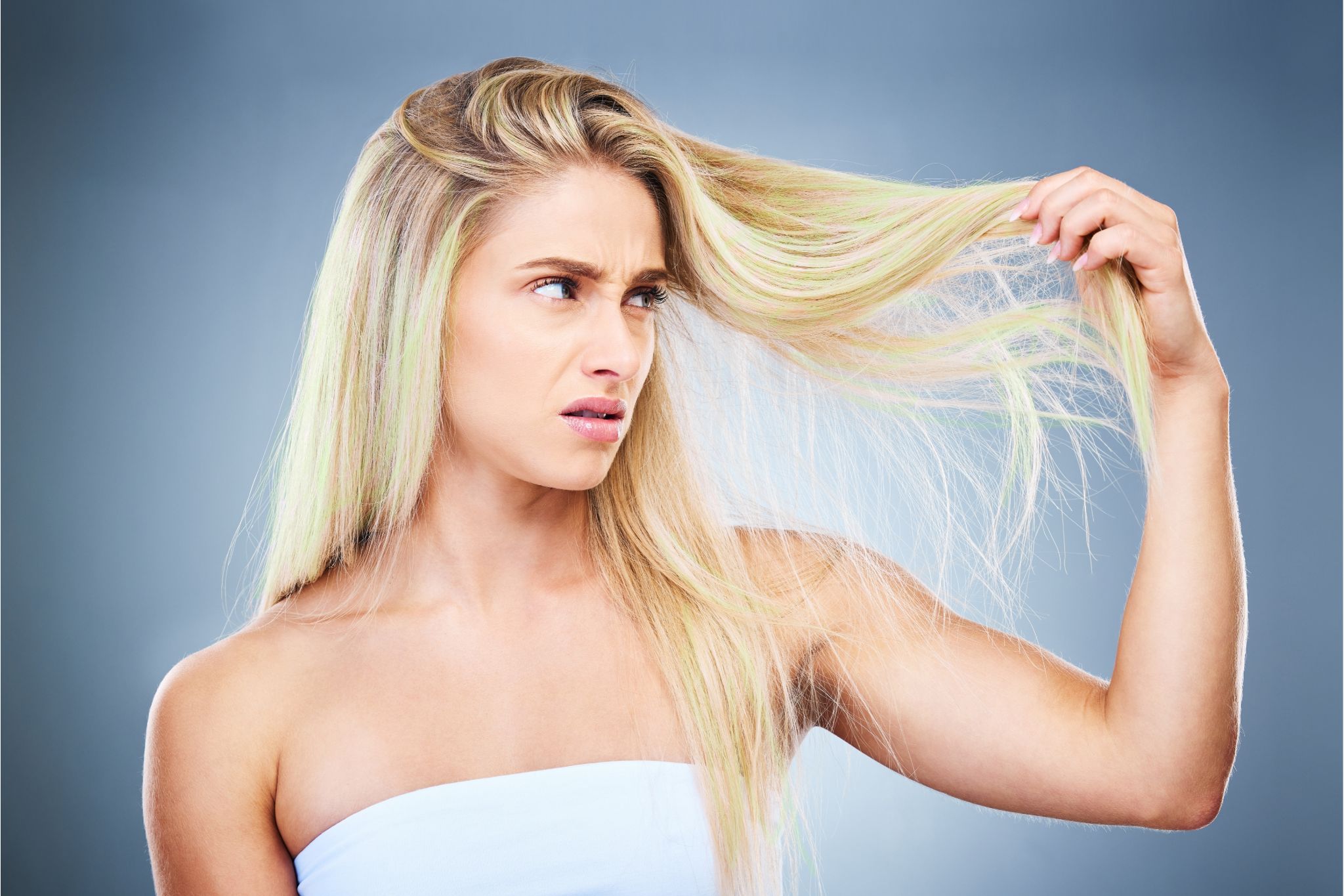 Woman with blonde hair suffering from green tint in her hair after swimming in a pool